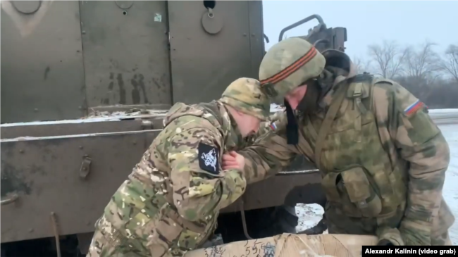Alexandr Kalinin, în timp ce transmite unui militar părți compenente pentru autovehicule