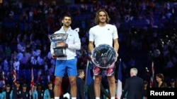 Tenisti serb, Novak Gjokoviq, dhe nënkampioni grek, Stefanos Tsitsipas, me trofetë e tyre përkatës pas ndeshjes së fundit në Australian Open Melburn, Australi. 29 janar 2023.