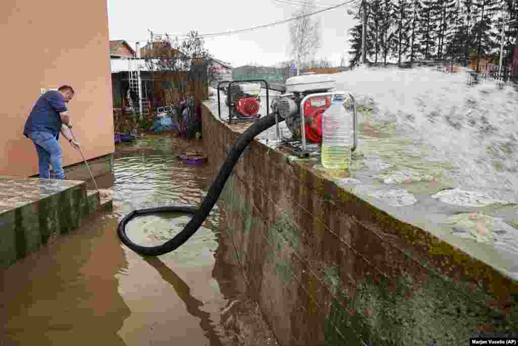 Meštanin ispumpava vodu iz dvorišta nakon poplava u Čačku, Srbija, 19.. januar