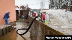 A man uses a pump to drain water from his yard in Cacak, Serbia, on January 19.