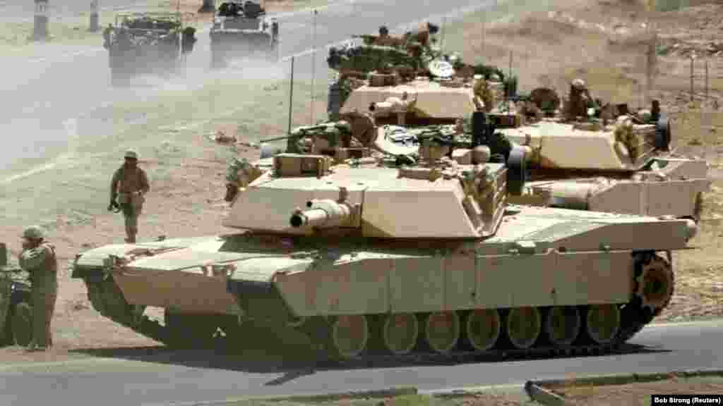 Tancuri U.S. Marine Corps M1A1 într-un schimb de focuri în apropierea principalului punct de control de circulație de la Fallujah, Irak, 24 iunie 2004. Versiunea de export a tancurilor Abrams e folosită de armatele din Australia, Egipt, Irak, Kuveit, Polonia și Arabia Saudită.&nbsp;