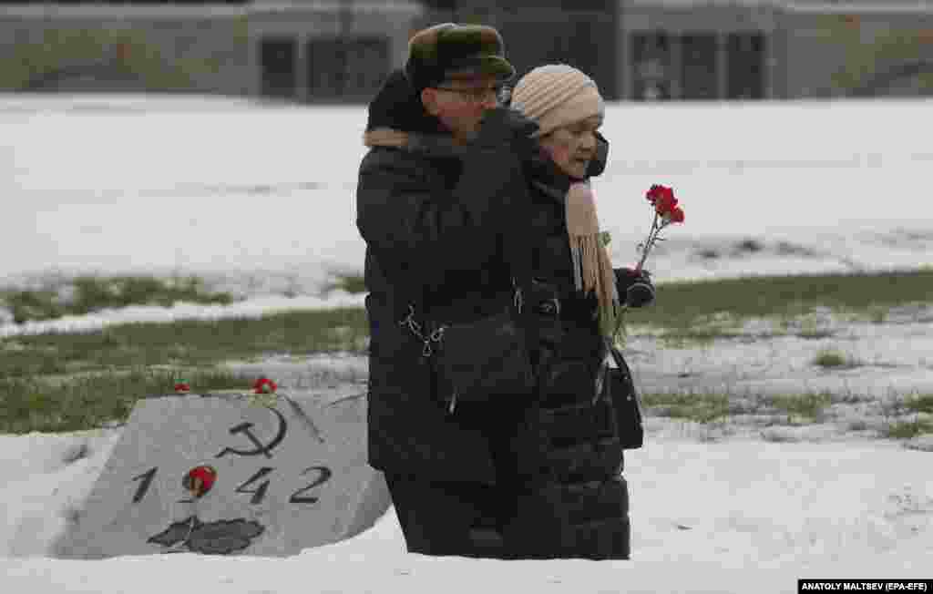 An elderly couple walks along a mass grave containing the victims of the Nazi siege of Leningrad at the Piskarevskoe Memorial Cemetery in St. Petersburg, marking the 79th anniversary of the liberation of Leningrad, the city&#39;s Soviet-era name. Up to 700,000 civilians are believed to have died from hunger, cold, shelling, and air bombardment during the siege, which lasted some 900 days.