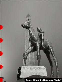 Плакат «Народ Казахстана — не террористы!» у скульптурной композиции на площади Республики. Алматы, 6 января 2022 года