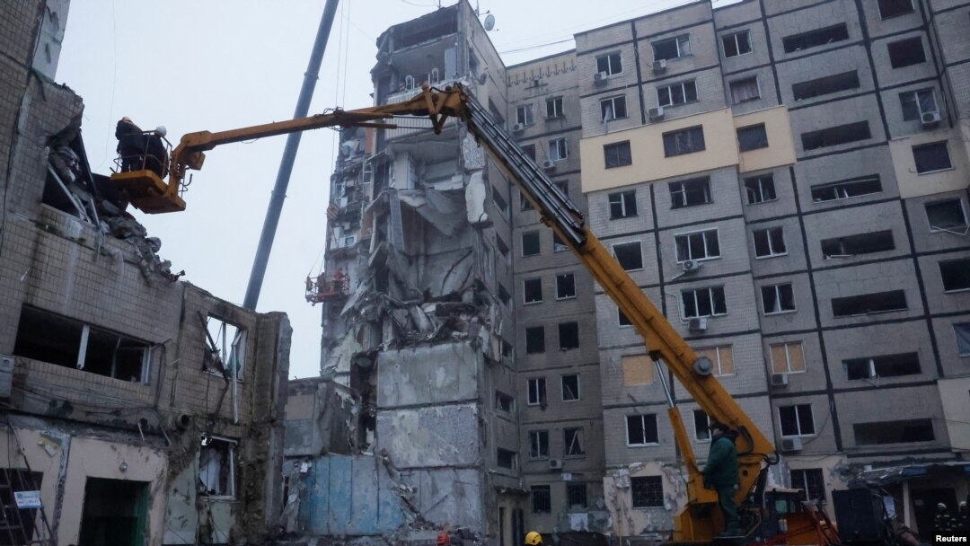 Аварийни служители работят на мястото, където жилищен блок беше силно повреден от руски ракетен удар в Днипро, 16 януари 2023 г.