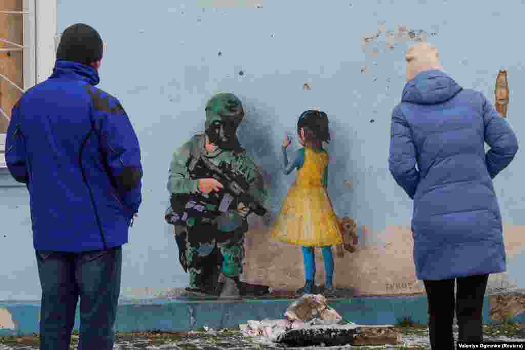 Another mural by Tvboy shows a little girl and a soldier on the war-scarred House of Culture in Irpin that was damaged during the Russian invasion and occupation.