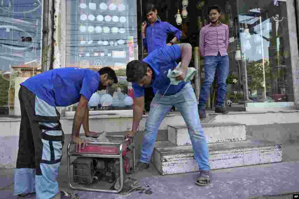 Ministar Dastigar je rekao da su se zbog nestabilnog napona sistemi isključili jedan po jedan, ali da ovo nije velika kriza. na fotografiji: trgovci pale agregat ispred prodavnice u Karačiju.