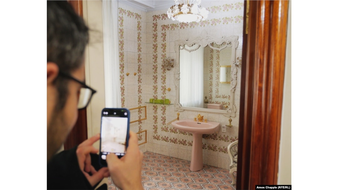 A visitor snaps a photo of a bathroom inside the Ceausescu Mansion.