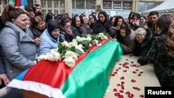 People gather around the coffin of Orkhan Askerov, a security guard at Azerbaijan's embassy in Iran who was shot dead by a gunman in an attack, in Baku on January 30.