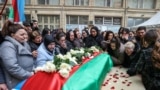 People gather around the coffin of Orkhan Askerov, a security guard at Azerbaijan's embassy in Iran who was shot dead by a gunman, during a procession in Baku on January 30.