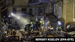 Echipele ucrainene de salvatori caută supraviețuitori după ce un bloc de apartamente a fost lovit de rachetele rusești la Harkov, Ucraina, 30 ianuarie 2023
