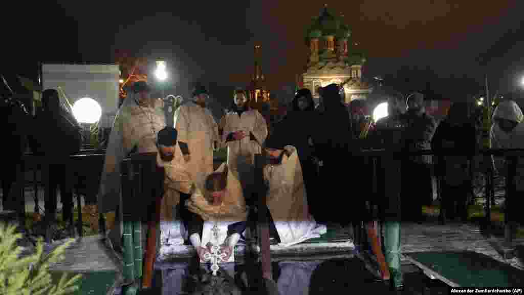 Preoții binecuvântează apa înghețată la Biserica Sfintei Treimi de la Moscova pe 18 ianuarie. Cu aproape 90 de milioane de credincioși, Biserica Ortodoxă Rusă binecuvântează în mod tradițional apele de două ori, o dată în ajun de Bobotează, a doua în ziua de Bobotează, pe 19 ianuarie.