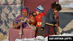 ماشومان او یوه افغان ښځه د خپل انګړ مخته 