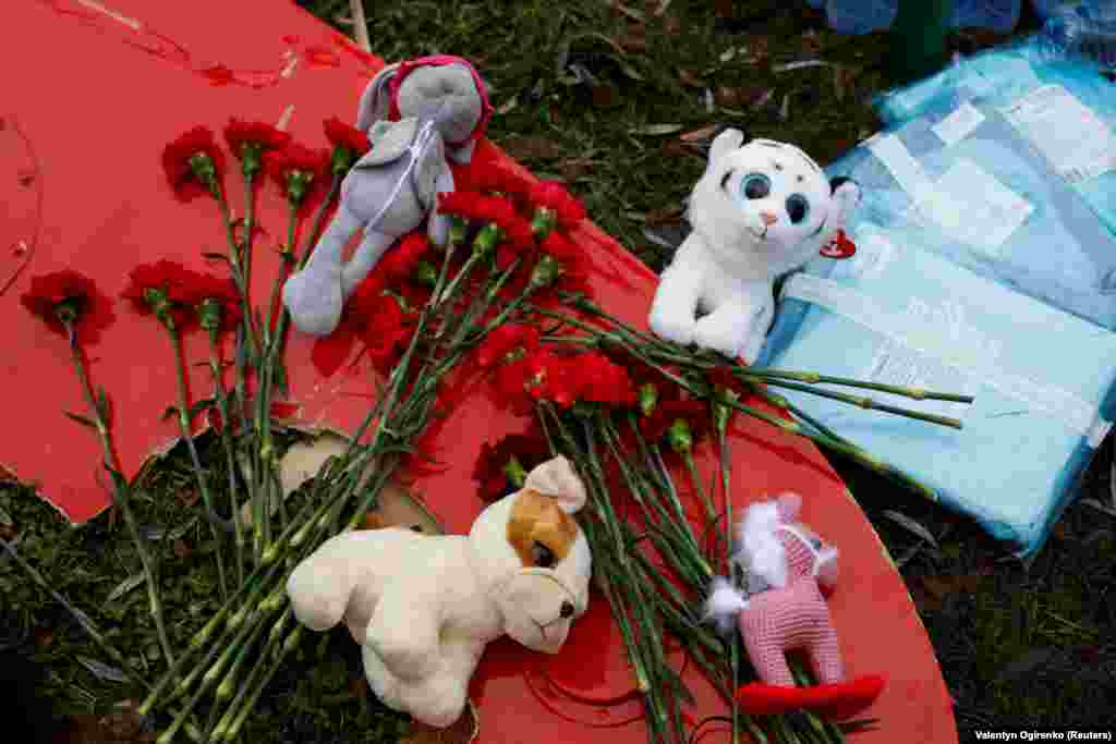 Tributes of stuffed animals and flowers are seen at the site of the helicopter crash.
