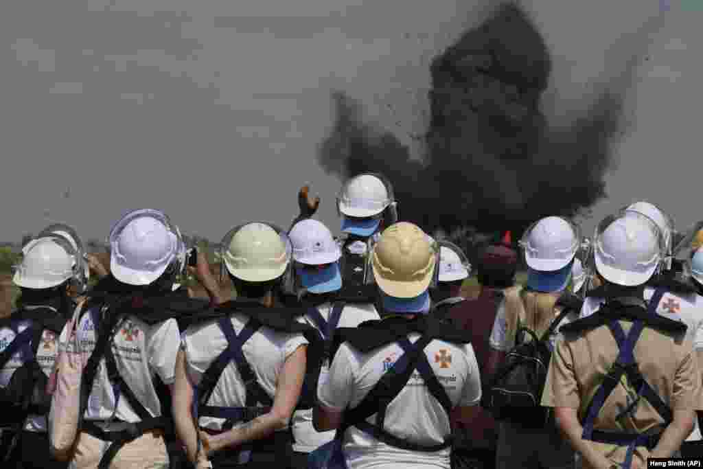 Ukrainian deminers view a controlled bomb explosion at a mine field in the village of Preytotoeung in Cambodia. Fifteen Ukrainian deminers are being trained by experts in Cambodia, who are among the world&#39;s best because of experience from clearing the leftovers of nearly three decades of war.&nbsp;