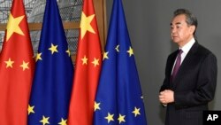 Former Chinese Foreign Minister Wang Yi stands next to the EU and Chinese flags as he waits for the arrival of European Council President Charles Michel in Brussels in 2019.