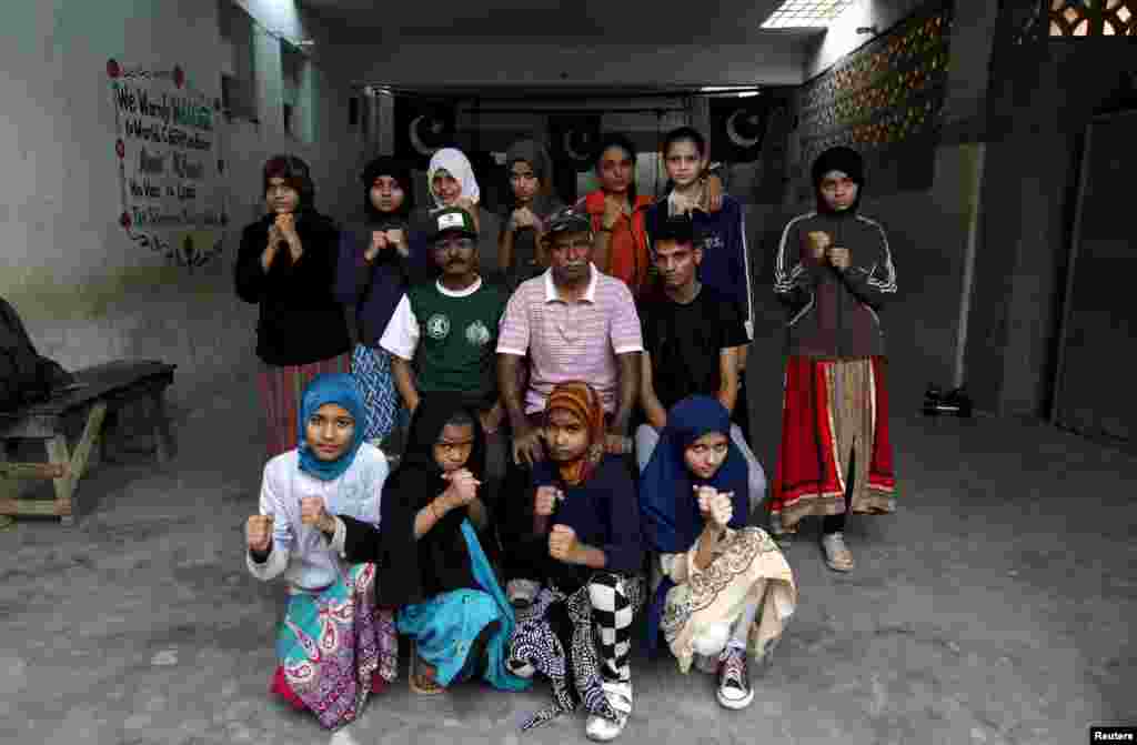 Girl trainees pose for a group photograph with their coach Yunus Qambrani and assistant coach Nadir at the boxing camp in Karachi.