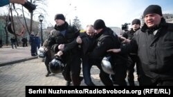 Police detain a protester at the march in Kyiv on March 8.