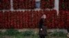 A woman poses for a picture as bunches of paprika hang on the walls of her house to dry in the village of Donja Lakosnica, Serbia. (Reuters/Marko Djurica)