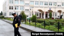 Polici duke qëndruar para shkollës në Rusi, ku sot ka pasur të shtëna