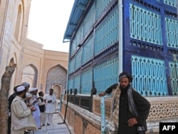 Men pray at the the shrine of a famous 11th-century Sufi poet and mystic philosopher on the outskirts of the western Afghan city of Herat.