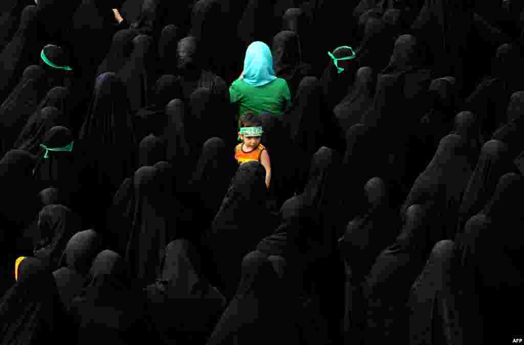 A child looks on as Iranian mourners attend the funeral of three members of the Islamic Republic's Revolutionary Guards reportedly killed in Syria, in Tehran on June 25. (AFP/Atta Kenare)