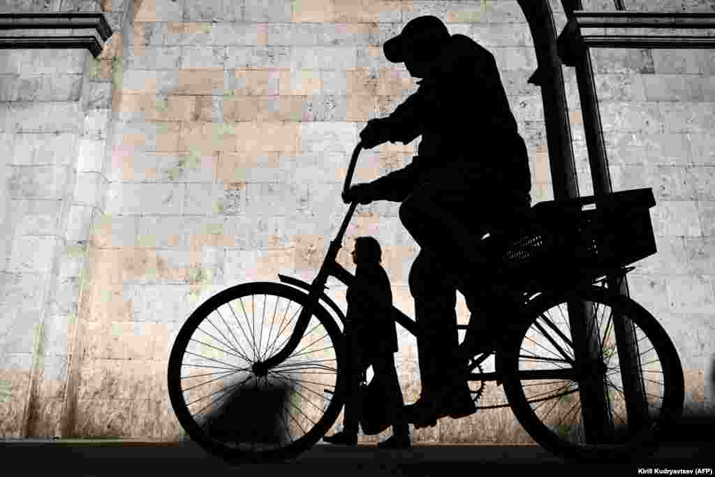 Солнечным утром в центре Москвы мужчина едет на велосипеде