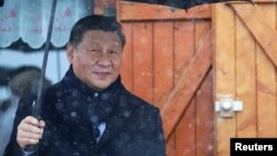 Chinese President Xi Jinping holds an umbrella outside a restaurant in the Pyrenees mountains of France on May 7.