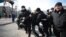 Police detain a protester at the march in Kyiv on March 8.