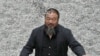 Chinese artist Ai Weiwei throws porcelain sunflower seeds into the air as he poses with his "Sunflower Seeds" installation in the Turbine Hall at the Tate Modern art gallery in London in October 2010.