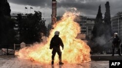 Выбух бутэлькі з запальнай сумесьсю каля паліцыянта падчас пратэсту ў Атэнах 4 лютага.