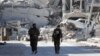 Fighters of the Syrian Democratic Forces walk along a road in Raqqa. 