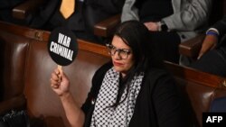 Rashida Tlaib, membră democrată a Congresului SUA, protestează înaintea discursului lui Netanyahu în legislativul american, cu o pancartă pe care scrie „criminal de război”.