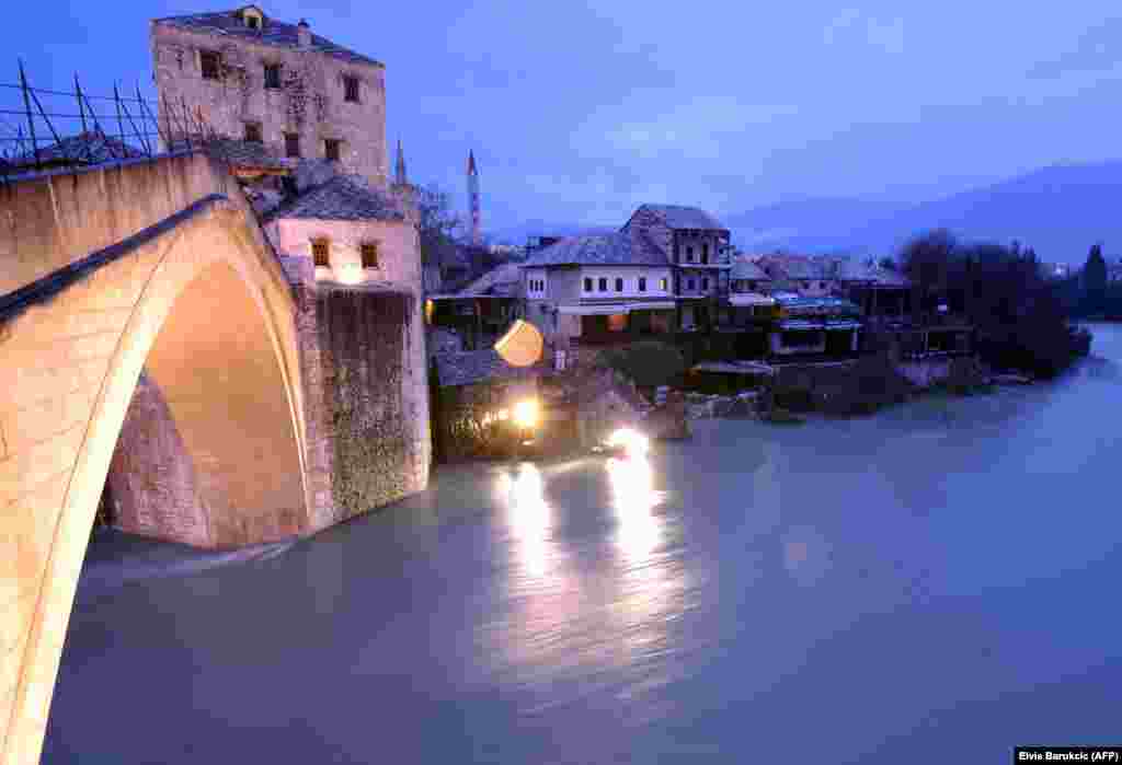 The historic bridge in Mostar, Bosnia, is seen after the level of the Neretva River rose approximately three meters compared to its normal levels. Water levels have dramaticaly risen countrywide due to snow melt and large quantities of rain in the past week. (AFP/Elvis Barukcic)