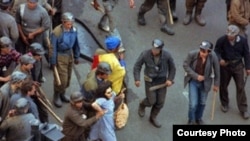 Una din fotografiile emblematice ale Marii Mineriade - 13-15 iunie 1990. Președintele Ion Iliescu, abia ales la 20 mai, a chemat minerii din Valea Jiului să facă „ordine” în București. În fapt, să intimideze opoziția. Femeia în albastru se numește Ioana Izabela Odor.
