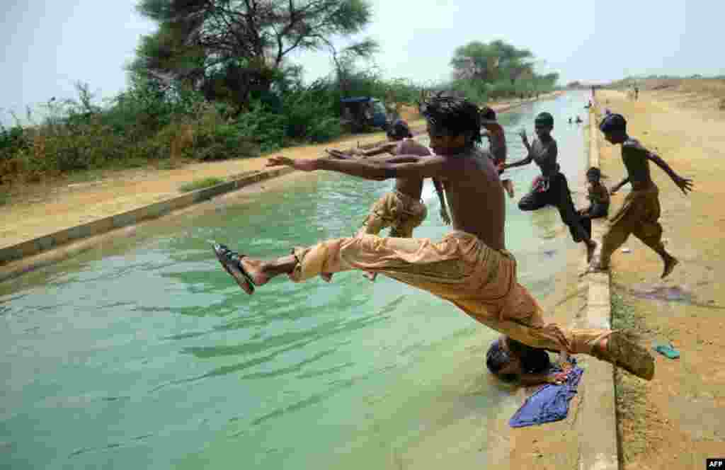 Pakistani youth enjoy swimming in a canal in Karachi. (AFP/Rizwan Tabassum)