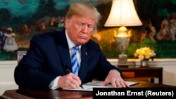 АҚШ президенті Дональд Трамп Иранмен жасалған ядролық келісімнен шығу жөніндегі құжатқа қол қойып отыр. Вашингтон, 8 мамыр 2018 жыл.
