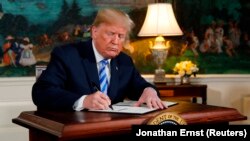 U.S. -- U.S. President Donald Trump signs a proclamation declaring his intention to withdraw from the JCPOA Iran nuclear agreement in the Diplomatic Room at the White House in Washington, U.S., May 8, 2018. 