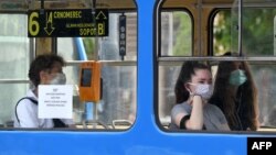 Илустрација - Луѓе со заштитни маски во јавен превоз во Загреб