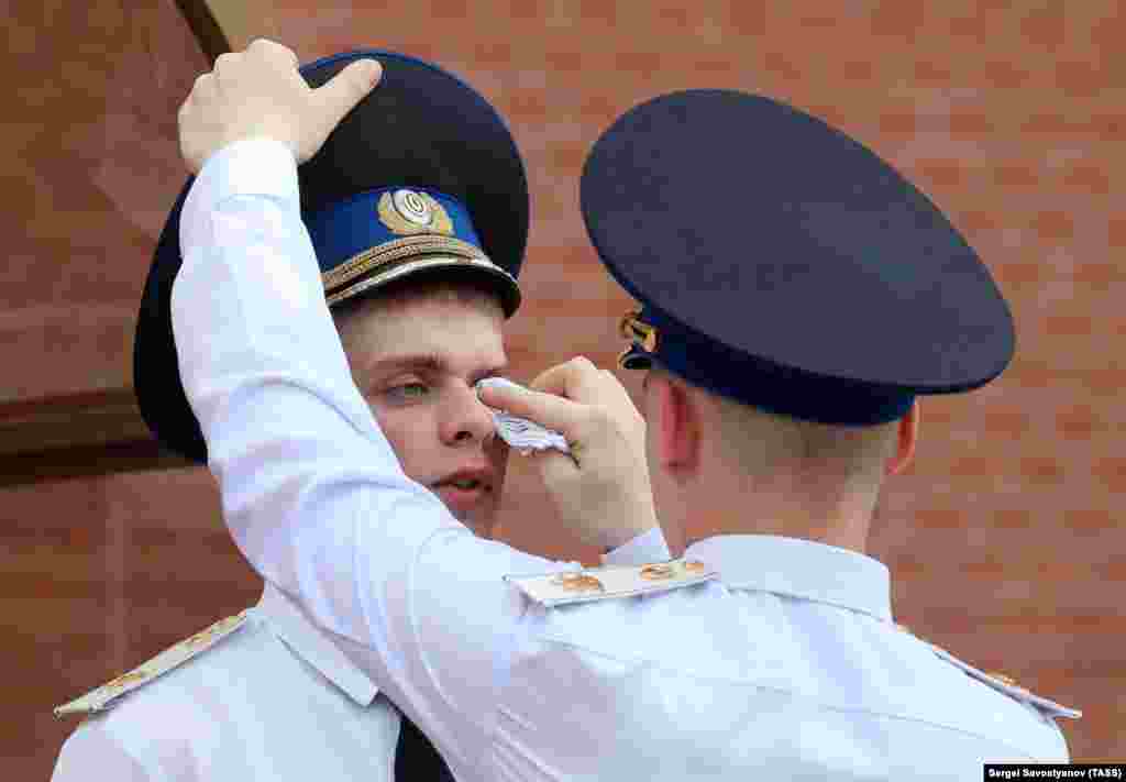 An honor guard is given assistance at the Eternal Flame at the Tomb of the Unknown Soldier during on a hot day in Moscow. (TASS/Sergei Savostyanov)