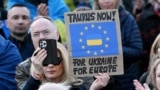 Жена държи плакат с надпис "Таурус сега - за Украйна, за Европа" по време на демонстрация в подкрепа на Украйна пред Бранденбургската врата в Берлин, 9 март 2025 г. 