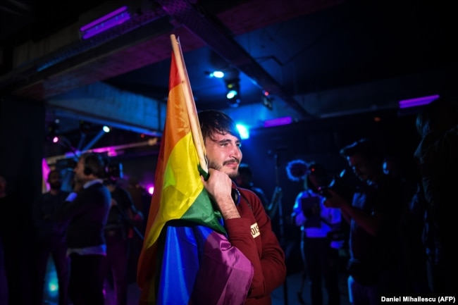Un uomo piange in un club di Bucarest mentre i membri della comunità LGBT aspettano i risultati del referendum dell’ottobre 2018.