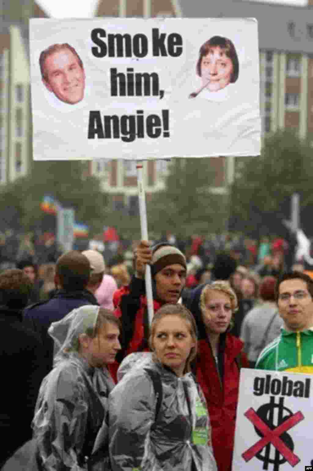 پلاکاردی علیه بوش و مرکل در دستان معترضین به G8