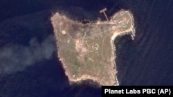  На супутниковому знімку, зробленому Planet Labs PBC, видно дим, який піднімається після ударів армії України по будівлях, зайнятих російськими військовими, та їхніх позиціях на острові Зміїний у Чорному морі, 7 травня 2022 року