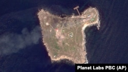 На супутниковому знімку, зробленому Planet Labs PBC, видно дим, який піднімається після ударів армії України по будівлях, зайнятих російськими військовими, та їхніх позиціях на острові Зміїний у Чорному морі, 7 травня 2022 року