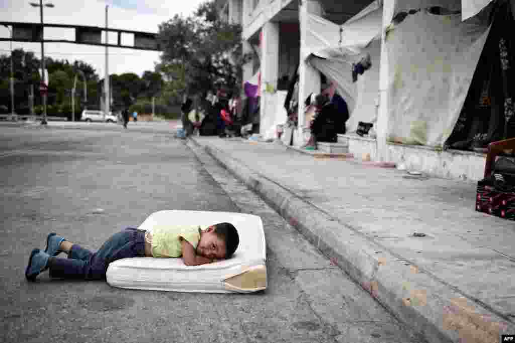 A refugee boy rests in a makeshift camp situated at the old Athens airport. The Greek asylum service launched the registration of the migrants inside some of the camps in an attempt to speed up the asylum process. (AFP/Louisa Gouliamaki)