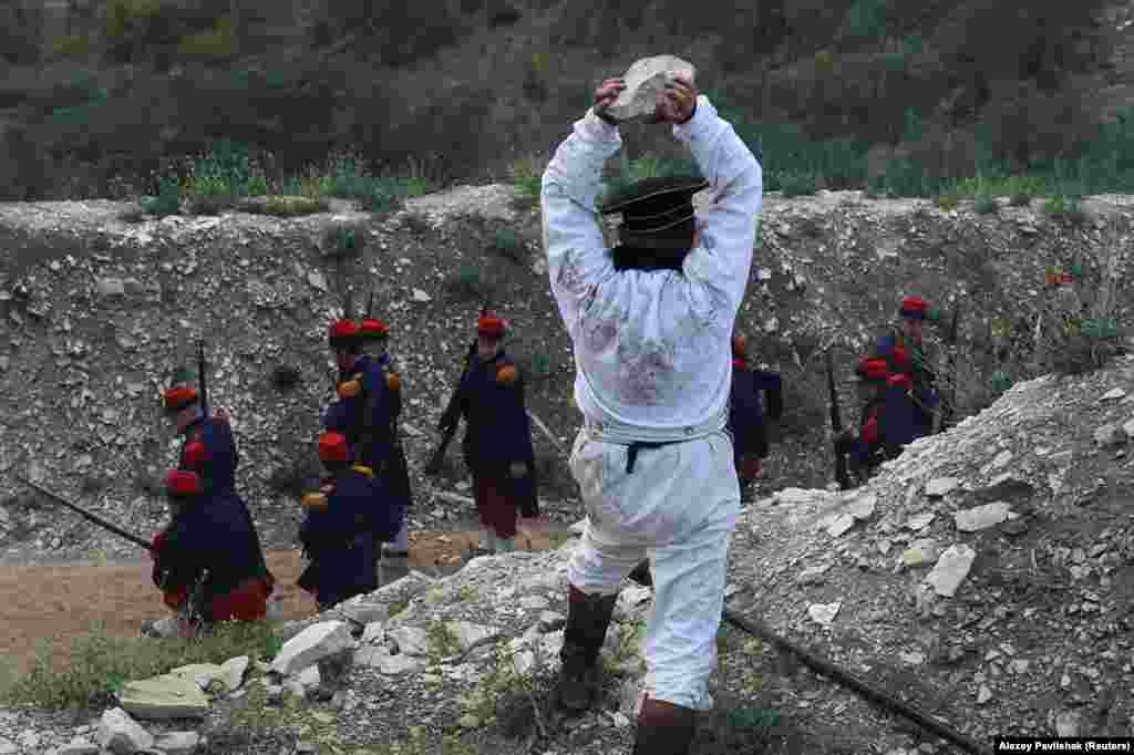 An actor mimics a rock attack on French troops during the mock battle. The Crimean War was fought between Russian forces on one side and Ottoman Turk, English, French, and Sardinians on the other over a complex web of geopolitics that unraveled as the Ottoman Empire continued its slow, inexorable decline. &nbsp;