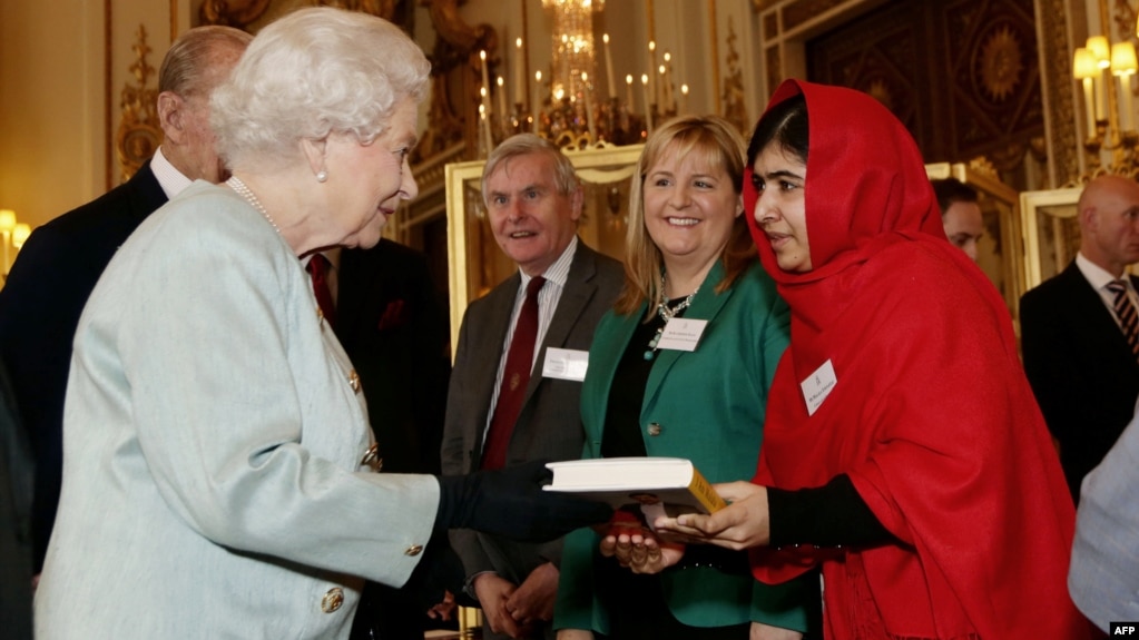  Малала Юсуфзай дава копие от книгата си на кралица Елизабет по време на банкет за младежта, образованието и Британската общественост в Бъкингамския замък в Лондон, 18 октомври 2013 година 