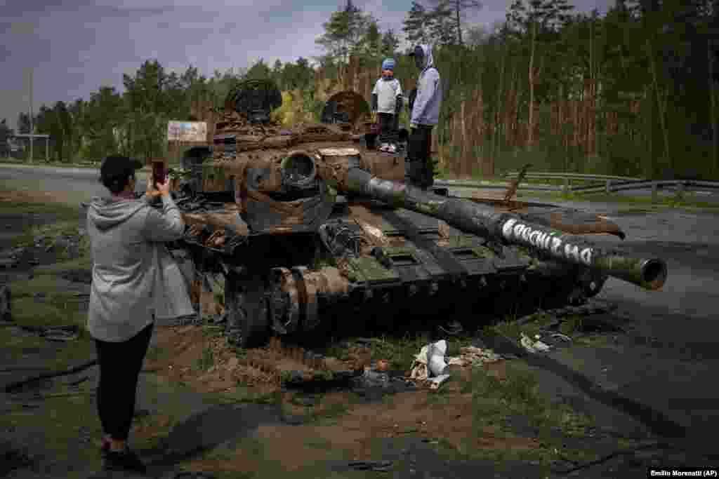 A hároméves Makszim és testvére, a 16 éves Dmitro fényképezkedik egy orosz tank roncsának tetején Kijev külvárosában