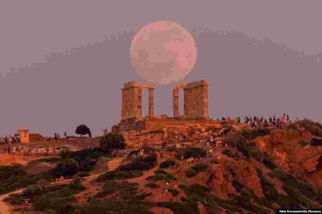 Hëna e plotë, e njohur ndryshe si &ldquo;Hëna e Luleve&rdquo;, teksa ngjitet mbi tempullin e Poseidonit, përpara eklipsit hënor në Kepin Sounion, pranë Athinës, Greqi, 15 maj, 2022.