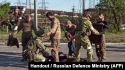 نیروهای روسی در حال بازرسی بدنی سربازان اوکراینی تسلیم شده در تاسیسات آزوف‌استال